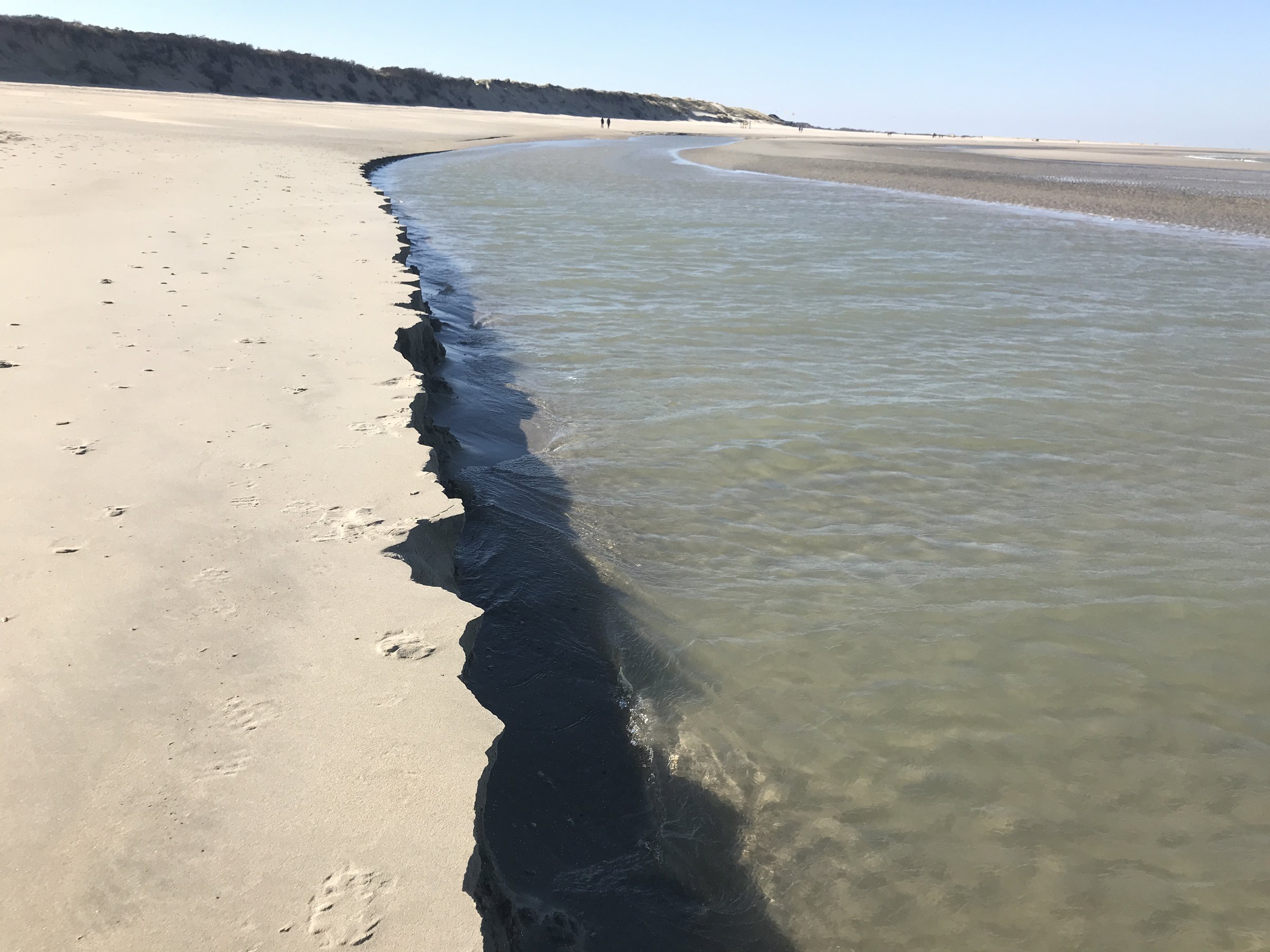 Emotionen aufloesen - Strandkante Strand, an dem das Wasser eine dunkle Kante in den Sand zieht